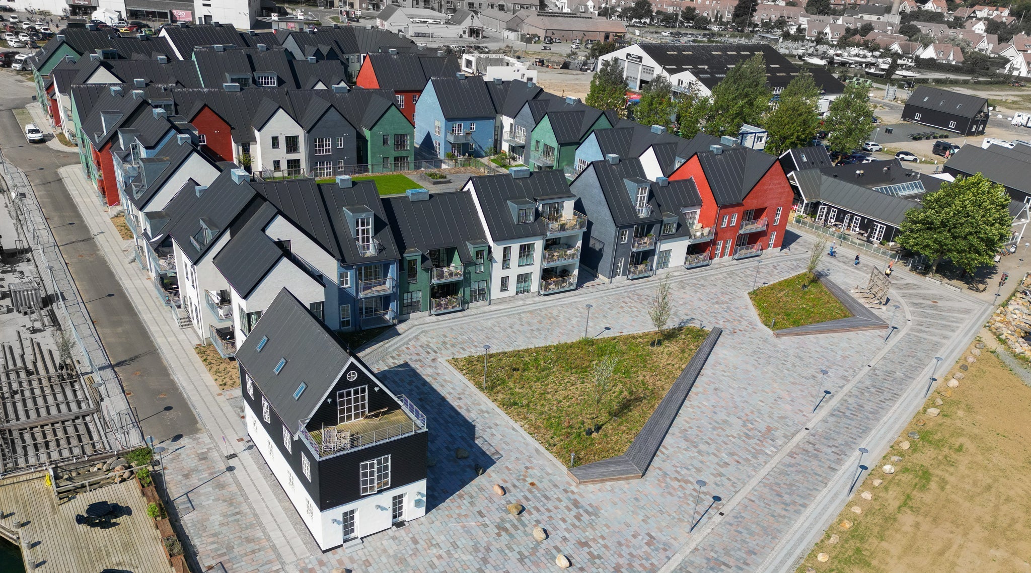 Luftfoto af Nordre Havnekaj i Kerteminde. Farverige byhuse ved havnen.