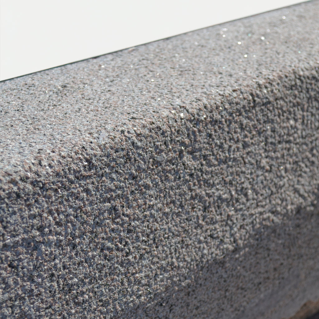 rødlig kantsten i granit, stokhugget overflade, g352, set i nærbillede.