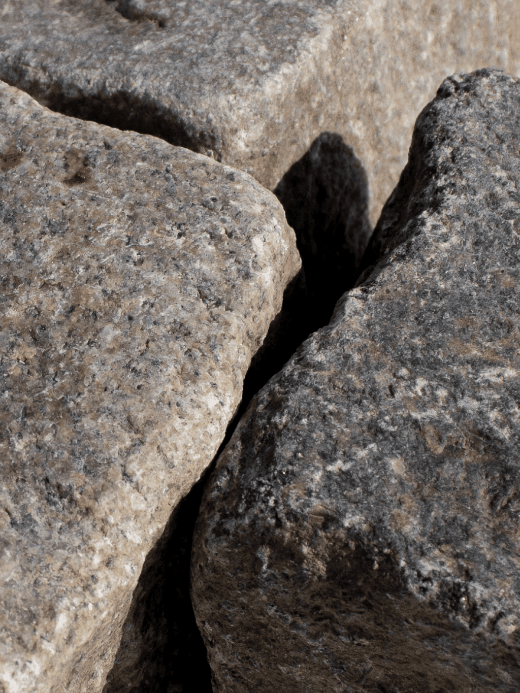 nær detalje af grå og beige chaussesten, nordisk mix, brugte/slidte.